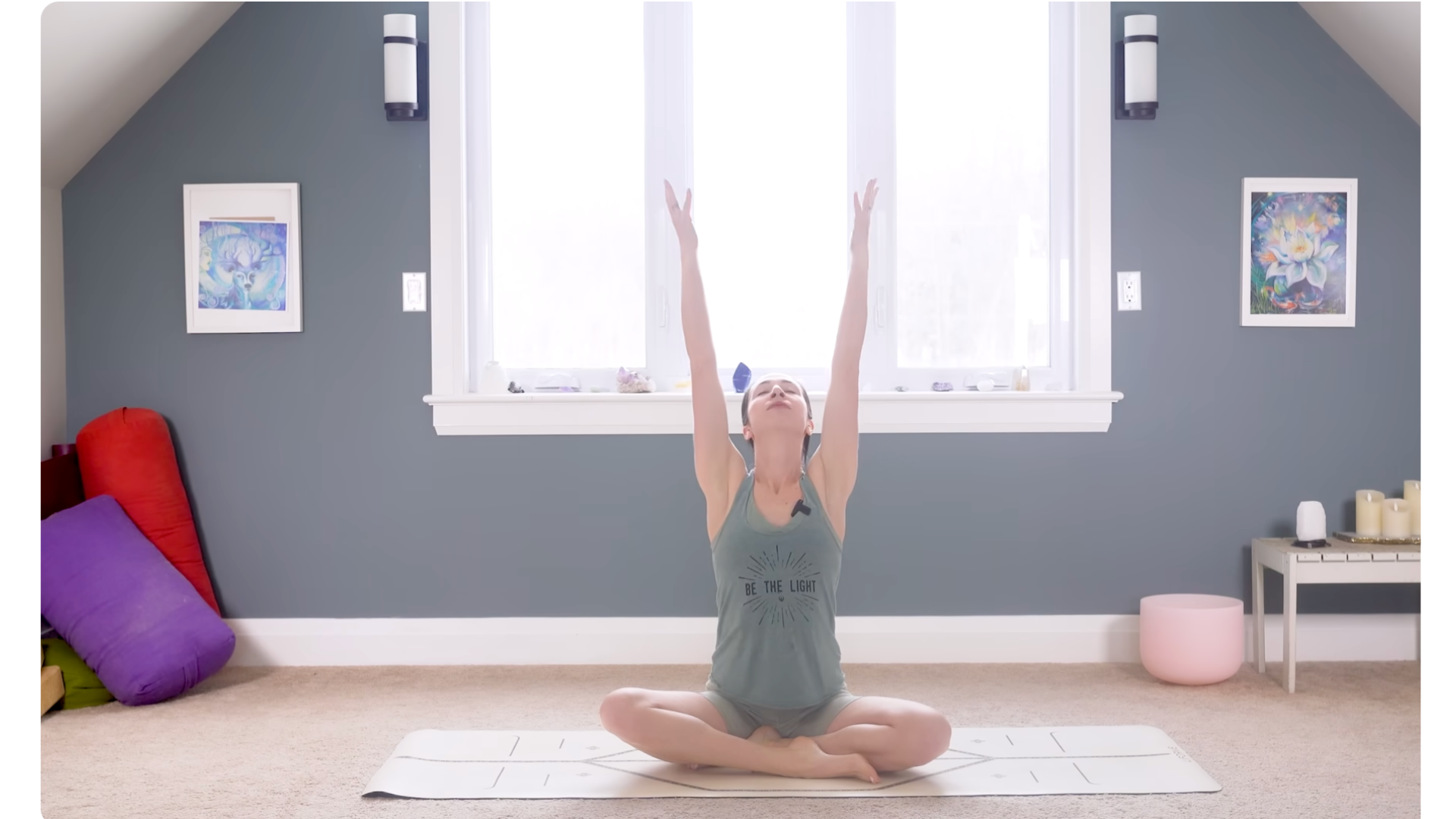 Woman sitting on a yoga mat with her arms reaching overhead